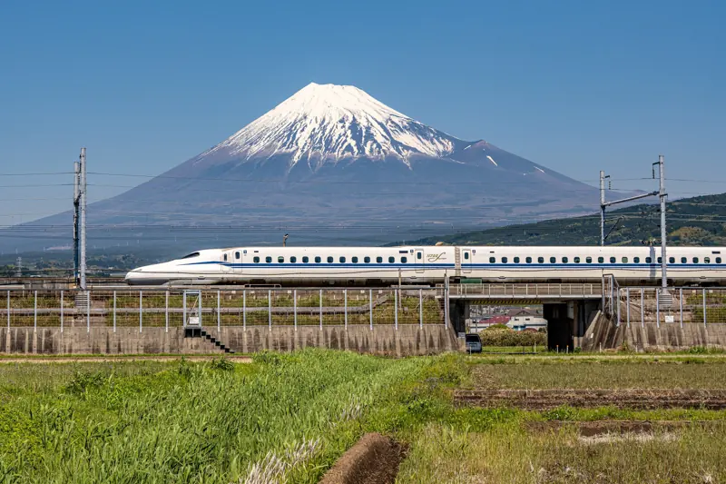 Shinkansen rijdt voorbij met de besneeuwde Fuji op de achtergrond